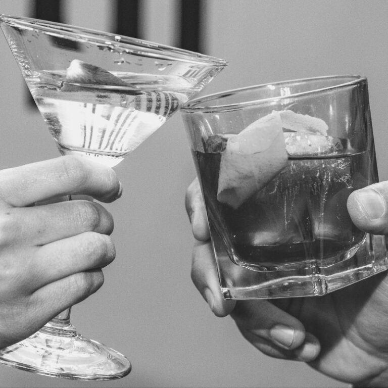 Two hands clinking cocktails at a Richmond cocktail bar