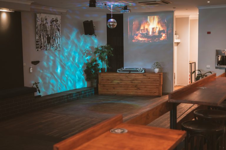 Dance floor and DJ booth with ambient lighting inside a function venue in Richmond