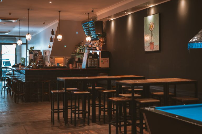 Bar area with high tables and a pool table inside a function venue in Richmond.