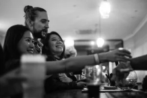 Three guests ordering drinks at the bar during an event at a function venue in Richmond