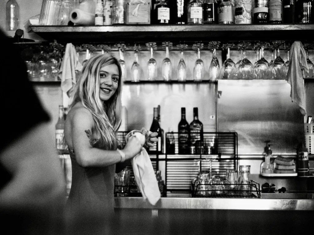 Smiling bartender polishing a glass behind the bar at a function venue in Richmond.